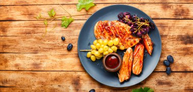 Kırsal ahşap masada üzümlü dilimlenmiş tavuk göğsü.