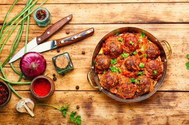 Domates soslu köfte ve ahşap masada kuşkonmaz fasulyesi.