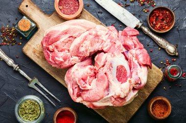 Bir parça domuz eti ve et bıçağı. Pişirmek için malzemeli taze domuz eti.