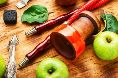 Ağızlık ve tüttüren nargile parçaları. Nargile tütünü, yeşil elma. Meyve tüttürüyor..