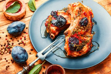 Ahşap masada erikli domuz rostosu.