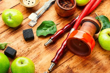 Ağızlık ve tüttüren nargile parçaları. Nargile tütünü, yeşil elma. Meyve tüttürüyor..