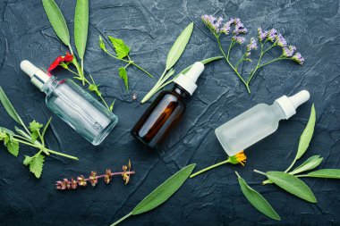 Bottles of tincture and healthy herbs and flowers.Alternative healthy medicine clipart