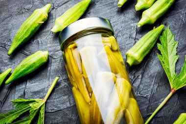Bamya kapsülleri cam kavanozda konserve. Ev yapımı tuzlu sebze turşusu..