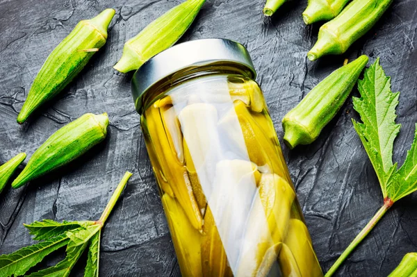 Bamya kapsülleri cam kavanozda konserve. Ev yapımı tuzlu sebze turşusu..