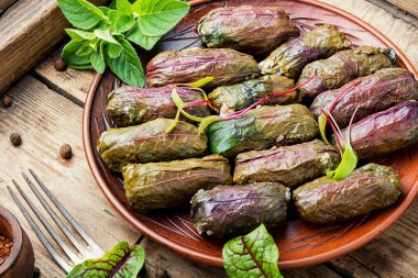 Köy ahşap masa üzerinde kuş yapraklarıyla geleneksel oryantal dolma