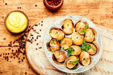 Salyangoz ya da sarımsaklı salyangoz, ahşap arka planda.