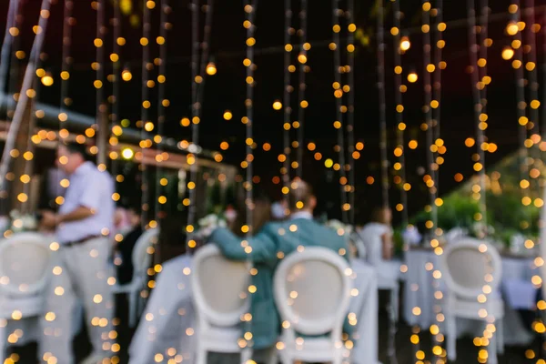 Mesa para recém-casados, luzes, lâmpadas no banquete da noite — Fotografia de Stock