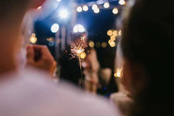 Düğünde çift, gecenin sonunda sarılıyor, ışıklı misafirler