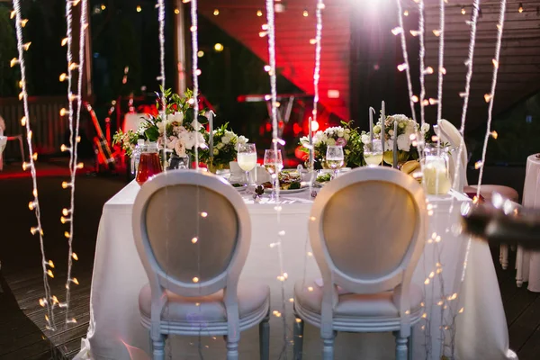 Table for newlyweds, lights, light bulbs at the evening banquet