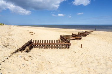 İngiltere'de Norfolk kumsal boyunca paslı demir fırtına savunma engelleri zikzak