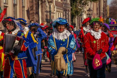 Dordrecht, Hollanda - 17 Kasım 2018: Saint Nicolaas İspanya, Sinterklaas geçit çocuklara hediyeler ve tatlılar veren yardımcıları piet kılık giyinmiş insanlar