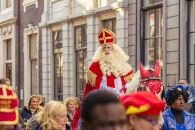 Dordrecht, Hollanda - 17 Kasım 2018: Saint Nicolaas beyaz atının Amerigo Dordrecht sokaklarında sürme sırasında gülümseyen Sinterklaas geçit töreni, yaşlı Merkezi aracılığıyla onun yol üzerinde insanlar tebrik
