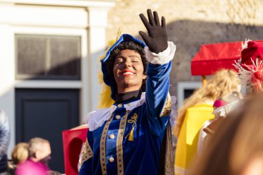 Dordrecht, Hollanda - 17 Kasım 2018: pınar, Saint Nicolaas İspanya, Dordrecht Sinterklaas sokakta sallayarak yardımcı kostüm giyinmiş güzel kız