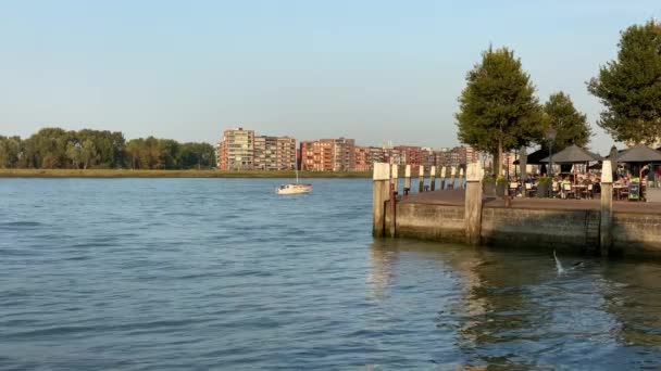 Velero en el río en el Groot Hoofd en Dordrecht personas sentadas en la terraza — Vídeo de stock