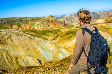 İzlanda, Landmannalaugar inanılmaz manzara üzerinde dağın tepesinde duran erkek uzun yürüyüşe çıkan kimse