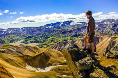 İzlanda, Landmannalaugar inanılmaz manzara üzerinde dağın tepesinde duran erkek uzun yürüyüşe çıkan kimse