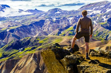İzlanda, Landmannalaugar inanılmaz manzara üzerinde dağın tepesinde duran erkek uzun yürüyüşe çıkan kimse