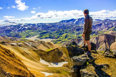 İzlanda, Landmannalaugar inanılmaz manzara üzerinde dağın tepesinde duran erkek uzun yürüyüşe çıkan kimse