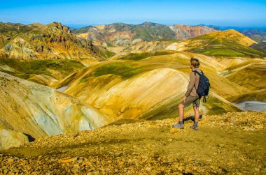 İzlanda, Landmannalaugar inanılmaz manzara üzerinde dağın tepesinde duran erkek uzun yürüyüşe çıkan kimse