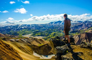 İzlanda, Landmannalaugar inanılmaz manzara üzerinde dağın tepesinde duran erkek uzun yürüyüşe çıkan kimse