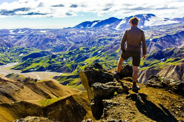 İzlanda, Landmannalaugar inanılmaz manzara üzerinde dağın tepesinde duran erkek uzun yürüyüşe çıkan kimse