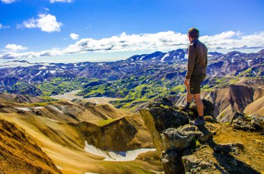 İzlanda, Landmannalaugar inanılmaz manzara üzerinde dağın tepesinde duran erkek uzun yürüyüşe çıkan kimse