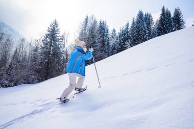 Kadın kar ayakkabıları ile orman Güney Almanya'da Oberstdorf, Bavyera Alpleri'nde kış manzara kar izinde hiking. Güzel manzara ile iğne yapraklı ağaçlar ve beyaz kar. Kış spor aktivitesi.