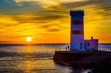 Gün batımında İzlanda sahil deniz feneri