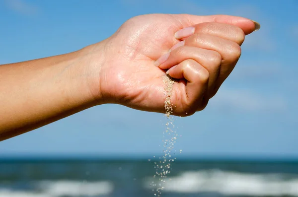 Girl has white sand in the hand at beautiful paradise beach