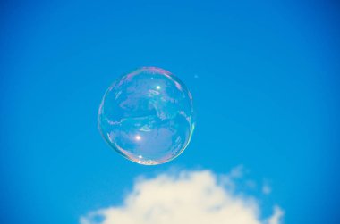 Mavi gökyüzü arka plan şeffaf sabun veya su balonu