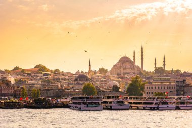 Eminönü liman gemi ve Süleymaniye Camii gün batımına, Istanbul, Türkiye'de Golden Horn Nehri, Fatih bölgesinde olan. Seyahat kavramı ve deniz manzara Istanbul tarihi bölümü'nün.