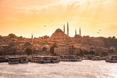 Eminönü liman gemi ve Süleymaniye Camii gün batımına, Istanbul, Türkiye'de Golden Horn Nehri, Fatih bölgesinde olan. Seyahat kavramı ve deniz manzara Istanbul tarihi bölümü'nün.