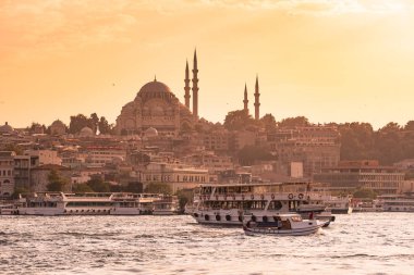 Eminönü liman gemi ve Süleymaniye Camii gün batımına, Istanbul, Türkiye'de Golden Horn Nehri, Fatih bölgesinde olan. Seyahat kavramı ve deniz manzara Istanbul tarihi bölümü'nün.