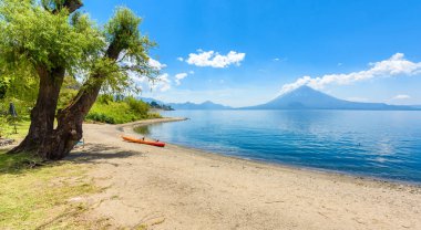 Cennet plaj sandalye ve Kayık göl Atitlan, Panajachel - rahatlatıcı ve Guatemala dağlık vulcano manzara manzara ile plajda eğlence