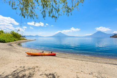 Cennet plaj sandalye ve Kayık göl Atitlan, Panajachel - rahatlatıcı ve Guatemala dağlık vulcano manzara manzara ile plajda eğlence