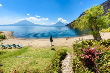 Cennet plaj sandalye ve Kayık göl Atitlan, Panajachel - rahatlatıcı ve Guatemala dağlık vulcano manzara manzara ile plajda eğlence