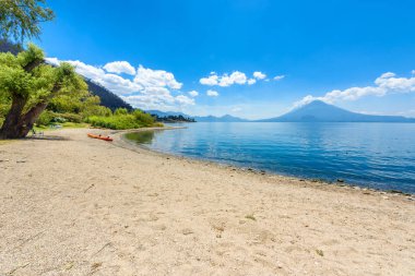 Cennet plaj sandalye ve Kayık göl Atitlan, Panajachel - rahatlatıcı ve Guatemala dağlık vulcano manzara manzara ile plajda eğlence