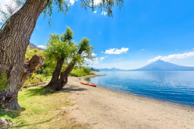 Cennet plaj sandalye ve Kayık göl Atitlan, Panajachel - rahatlatıcı ve Guatemala dağlık vulcano manzara manzara ile plajda eğlence