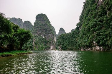 Trang Bir Manzara karst kuleleri ve nehir boyunca bitkiler (Unesco Dünya Mirası) tarafından oluşturulan Tekne mağara turu. Vietnam topraklarındaki Halong Körfezi. Ninh Binh province, Vietnam.