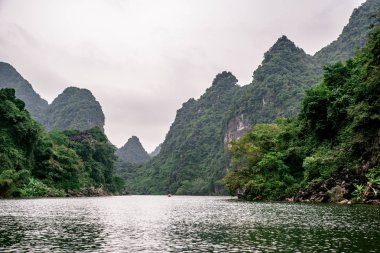 Trang Bir Manzara karst kuleleri ve nehir boyunca bitkiler (Unesco Dünya Mirası) tarafından oluşturulan Tekne mağara turu. Vietnam topraklarındaki Halong Körfezi. Ninh Binh province, Vietnam.