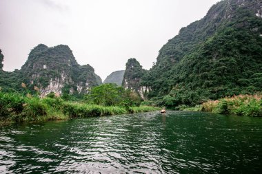 Trang Bir Manzara karst kuleleri ve nehir boyunca bitkiler (Unesco Dünya Mirası) tarafından oluşturulan Tekne mağara turu. Vietnam topraklarındaki Halong Körfezi. Ninh Binh province, Vietnam.