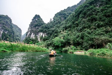 Trang Bir Manzara karst kuleleri ve nehir boyunca bitkiler (Unesco Dünya Mirası) tarafından oluşturulan Tekne mağara turu. Vietnam topraklarındaki Halong Körfezi. Ninh Binh province, Vietnam.