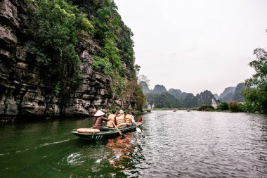 Trang Bir Manzara karst kuleleri ve nehir boyunca bitkiler (Unesco Dünya Mirası) tarafından oluşturulan Tekne mağara turu. Vietnam topraklarındaki Halong Körfezi. Ninh Binh province, Vietnam.