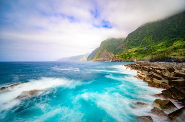Madeira Adası'ndaki Ponta do Poiso'da Gelin Peçe Şelalesi (Veu da noiva) ile güzel vahşi sahil manzarası. Porto Moniz yakınında, Seixal, Portekiz'den görünüm.