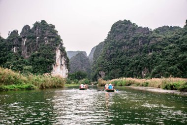 Trang Bir Manzara karst kuleleri ve nehir boyunca bitkiler (Unesco Dünya Mirası) tarafından oluşturulan Tekne mağara turu. Vietnam topraklarındaki Halong Körfezi. Ninh Binh province, Vietnam.