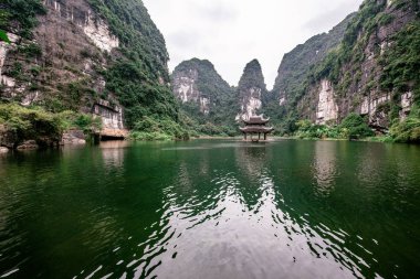 Trang Bir Manzara karst kuleleri ve nehir boyunca bitkiler (Unesco Dünya Mirası) tarafından oluşturulan Tekne mağara turu. Vietnam topraklarındaki Halong Körfezi. Ninh Binh province, Vietnam.
