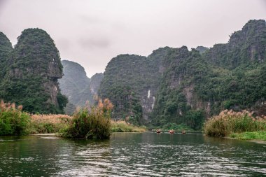 Trang Bir Manzara karst kuleleri ve nehir boyunca bitkiler (Unesco Dünya Mirası) tarafından oluşturulan Tekne mağara turu. Vietnam topraklarındaki Halong Körfezi. Ninh Binh province, Vietnam.