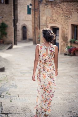 Genç asyalı kız yaz günü Monticchiello kasabasında yürüyor. Geleneksel eski taş evler ile Amazing gezinti - Toskana, İtalya, Avrupa