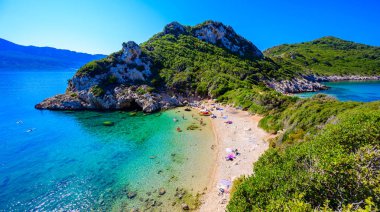 Porto Timoni 'nin Afionas plajı, Korfu, İyon adası, Yunanistan ve Avrupa' da kristal berrak gök mavisi suyu bulunan bir cennet çifte kumsalı.